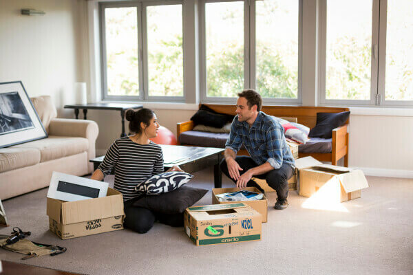 A couple unpacking their belongings in their new house.